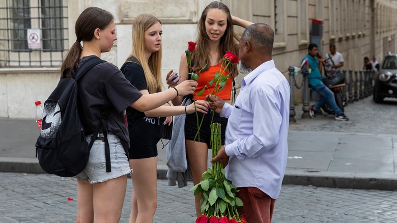 Three women being handed roses