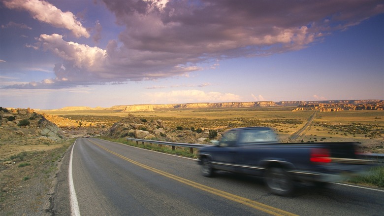 Truck driving in blurred motion into huge desert view