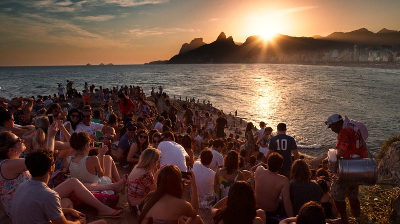 Crowds on Arpoador Rock overlooking the sunset on Ipanema Beach in Brazil