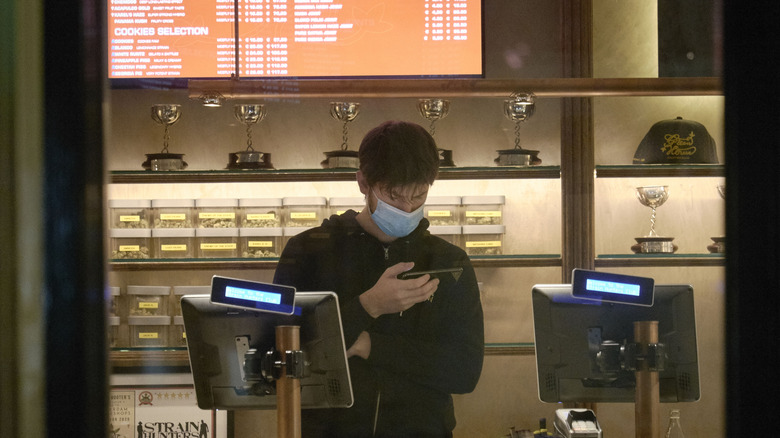 A masked seller in an Amsterdam coffeeshop