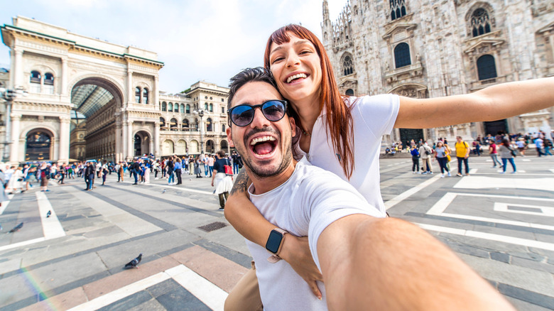 A couple taking a picture in front of the Duomo