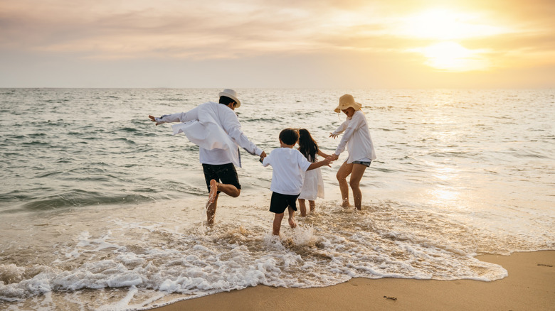 A family splashing around in the waves at the beach