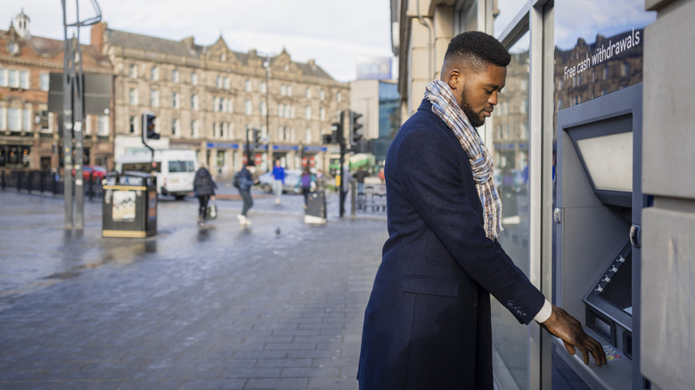 Man withdrawing money from an ATM in European city