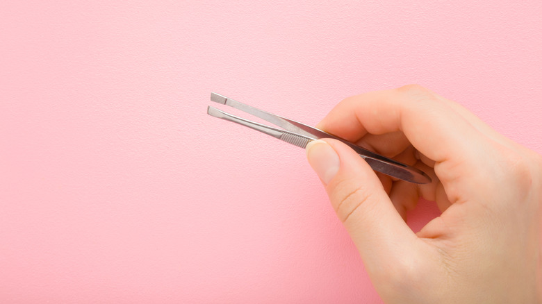 Holding pair of tweezers