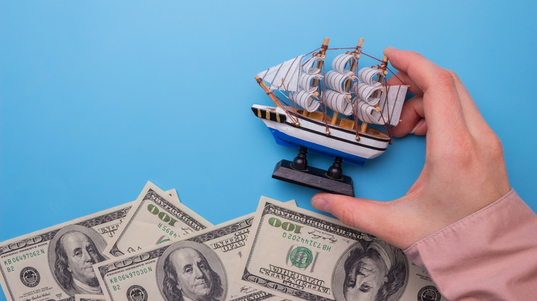 Toy ship "sailing" on $100 bills