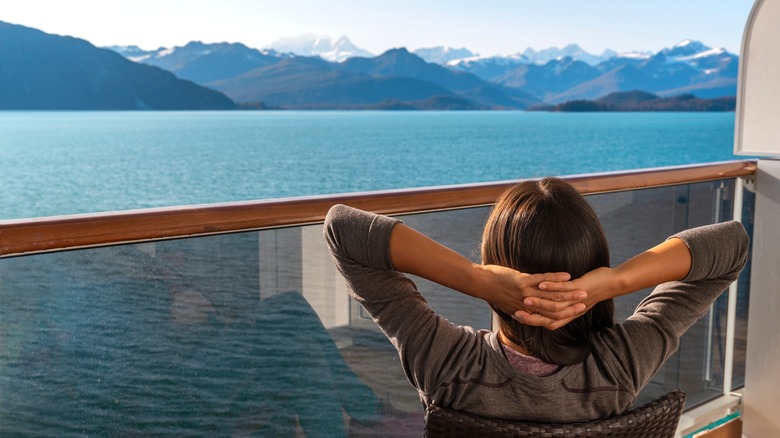 Woman on balcony viewing Alaskan coastline