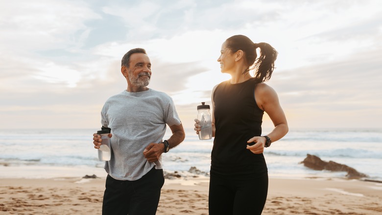 Beach couple with water bottles