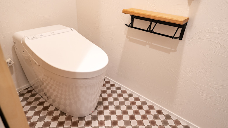 Japanese TOTO toilet in modern home with checkered tiled floors