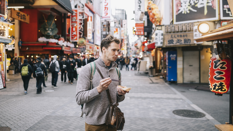 man eating on tokyo street