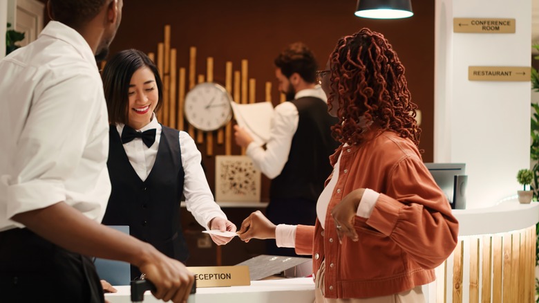 A woman checking into a hotel