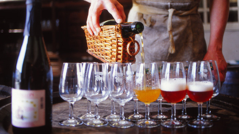 A waiter pouring beer into glasses