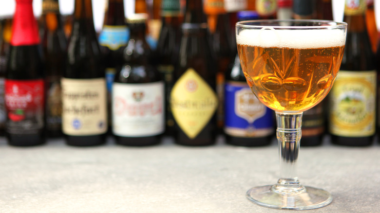 A glass of beer among different beer bottles