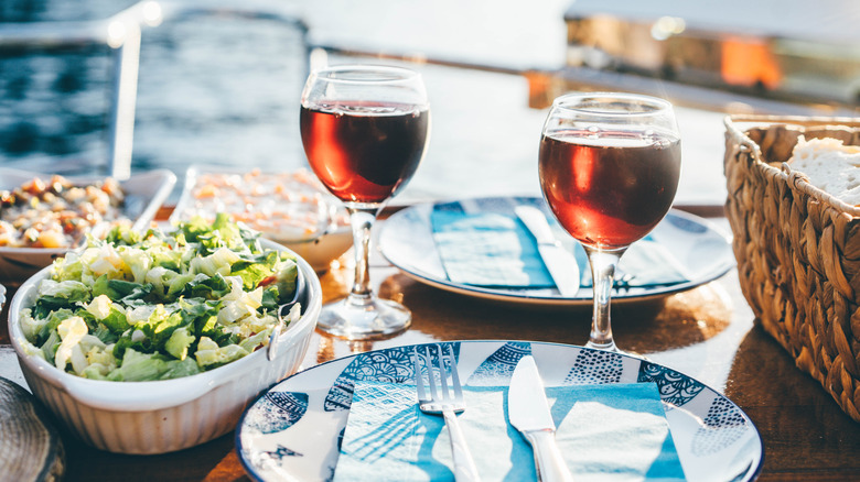 Two glasses of red wine and a picnic salad with bread