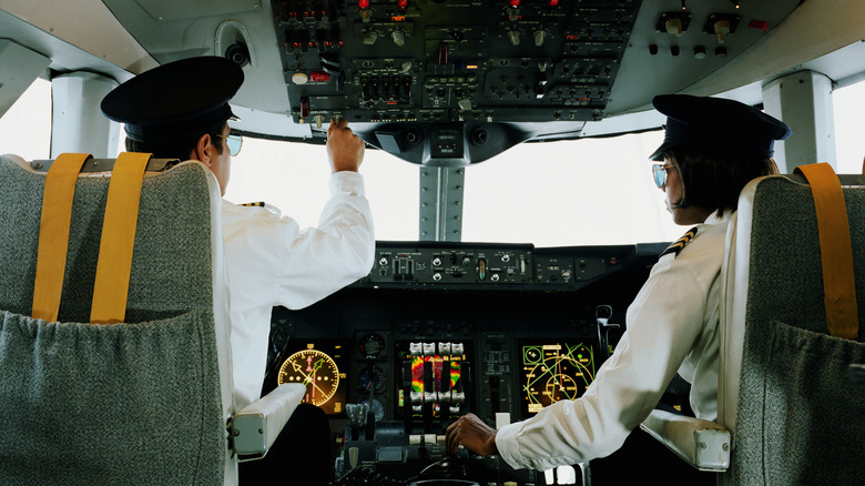 Male and female pilot on plane