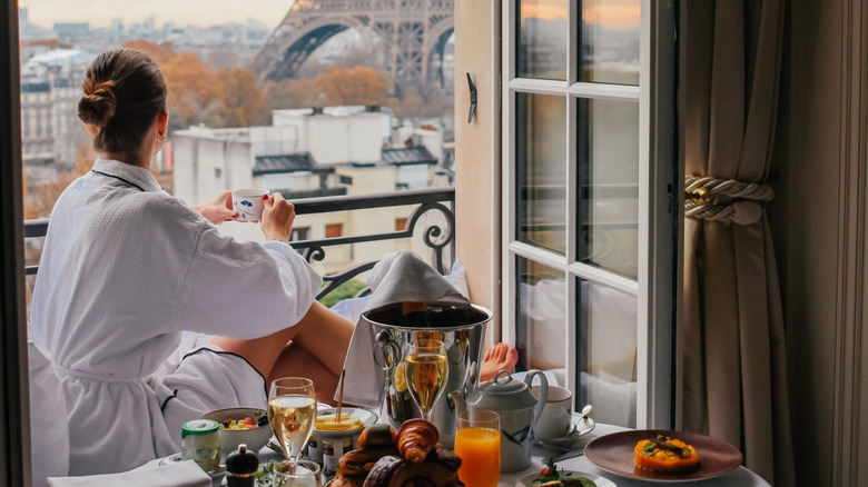 A woman eating on her window sill in her Paris hotel room