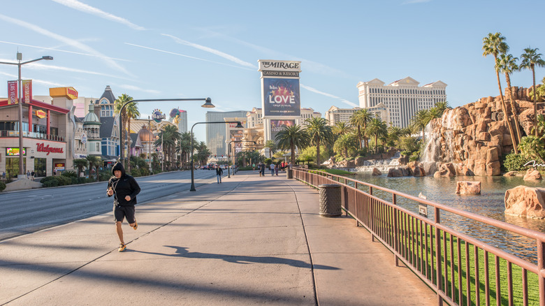 Man jogging down the street in Las Vega with palm trees and Mirage casino in background