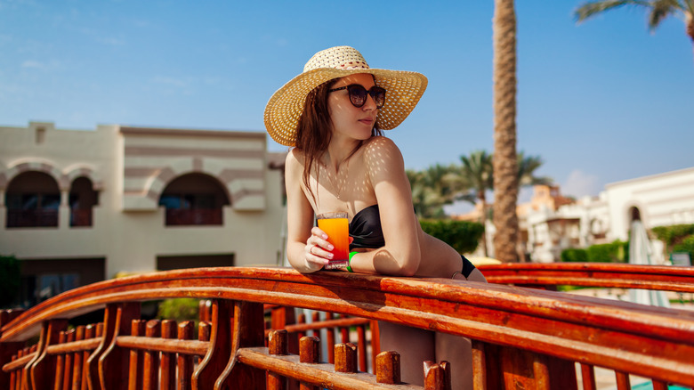 Woman in a bikini with a cocktail enjoying an all-inclusive resort