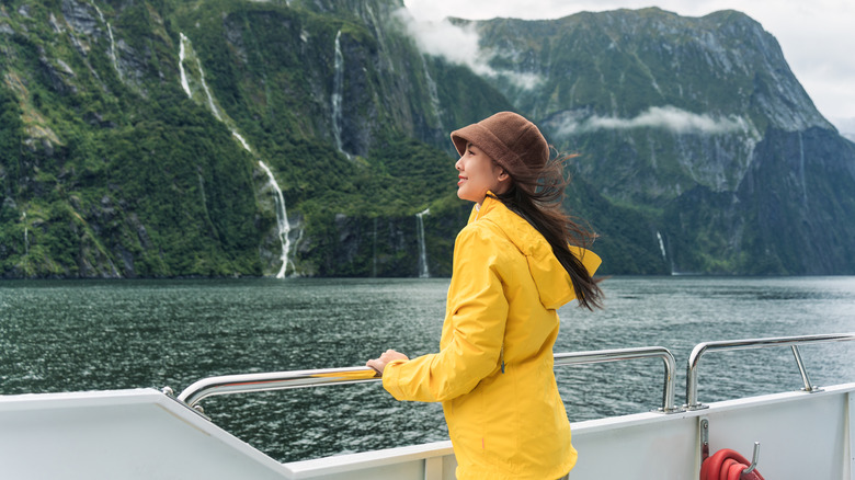 Solo female traveler on a boat looking at the scenery in New Zealand