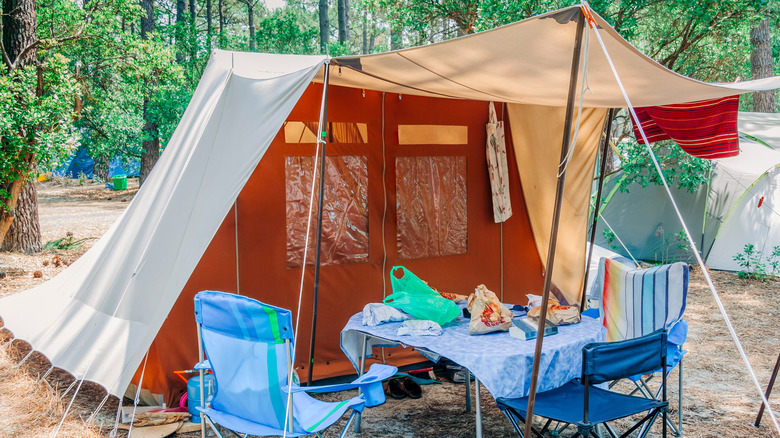 Tent with table and chairs in forest