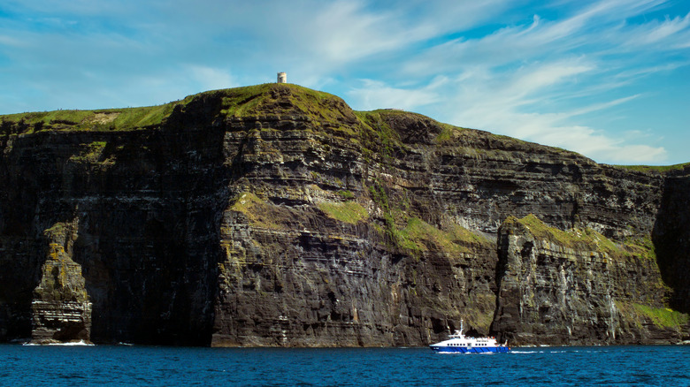 Boat cruises along base of Cliffs of Moher