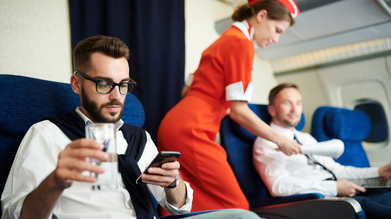 Flight attendant and passengers in the first class cabin