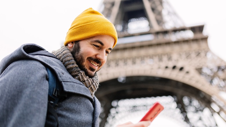 Man using phone at Eiffel Tower