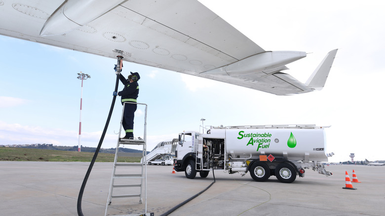 Airplane being refueled by a worker