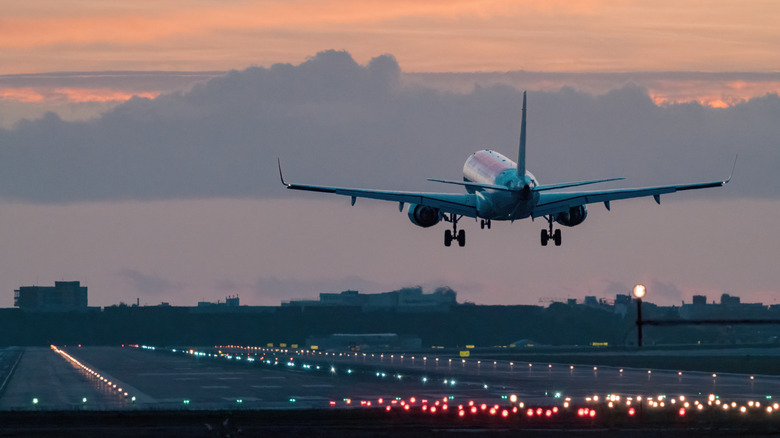 An airplane landing safely at sunrise