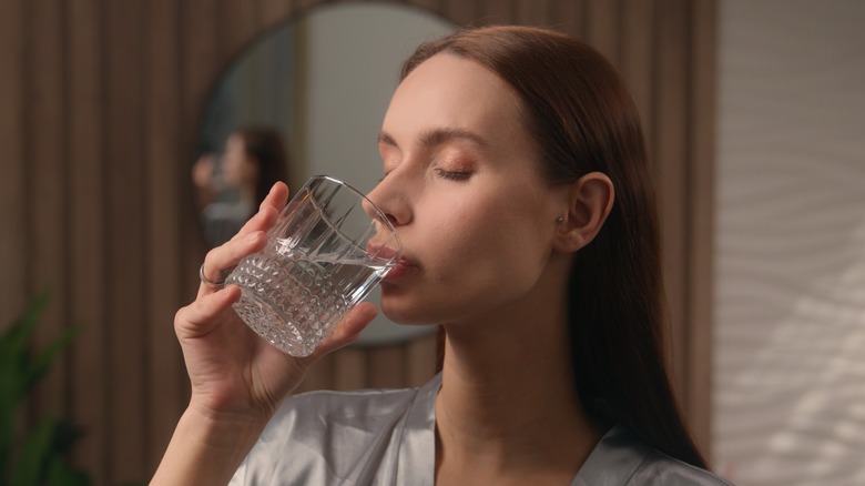 Woman drinking from a hotel water glass