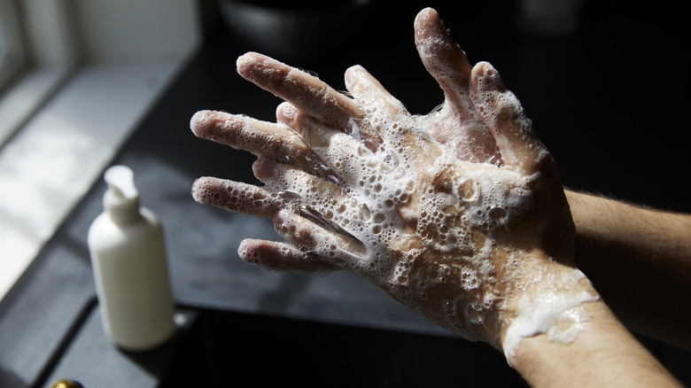 Aperson washing their hands with soap.