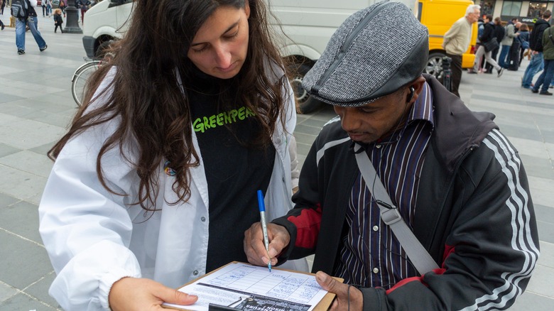 Person signing petition on street