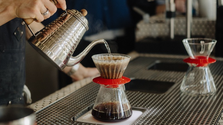 barista pouring coffee into filter