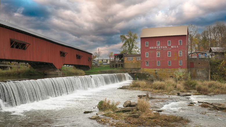 Covered bridge and Bridgeton Mill next to small waterfall