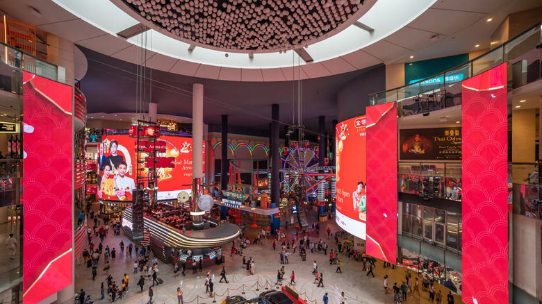 SkyAvenue shopping mall atrium with red LED lights and people shopping