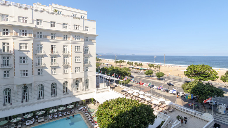 Side view of the white facade and pool of Copacabana Palace overlooking Copacabana Beach