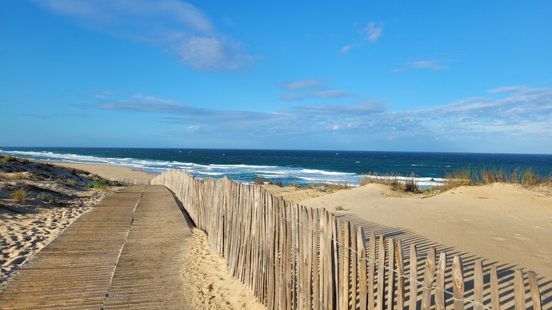 Empty beach at La Jenny naturist resort with the ocean in the background