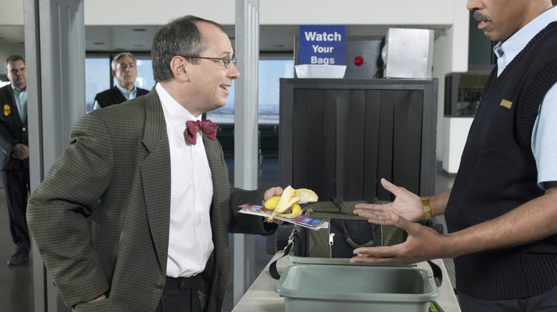 Man with banana speaks with TSA agent at airport security