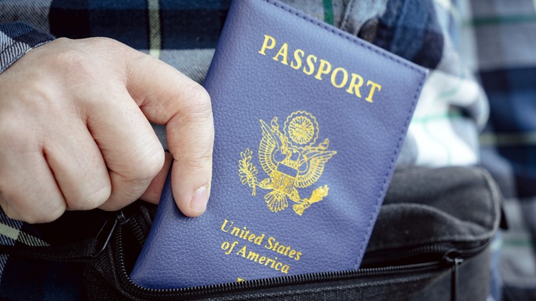 Person putting a passport in a zippered pocket