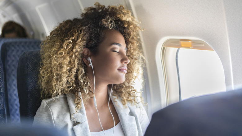 Airplane passenger wearing earphones