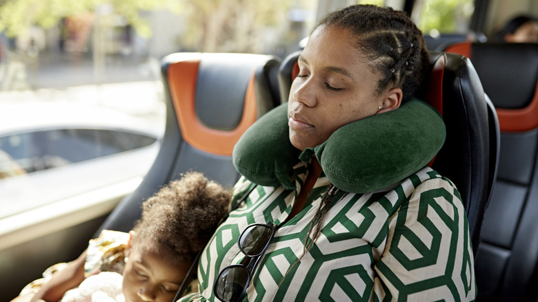 Parent using neck pillow while traveling with child