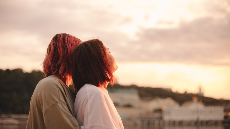 couple embracing watching sunset