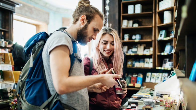 Two travelers checking out goods in a store