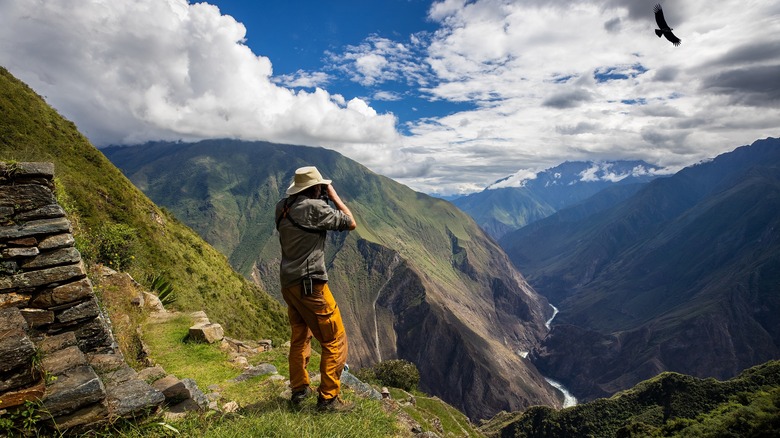 hiker looks out at view from Choquequirao
