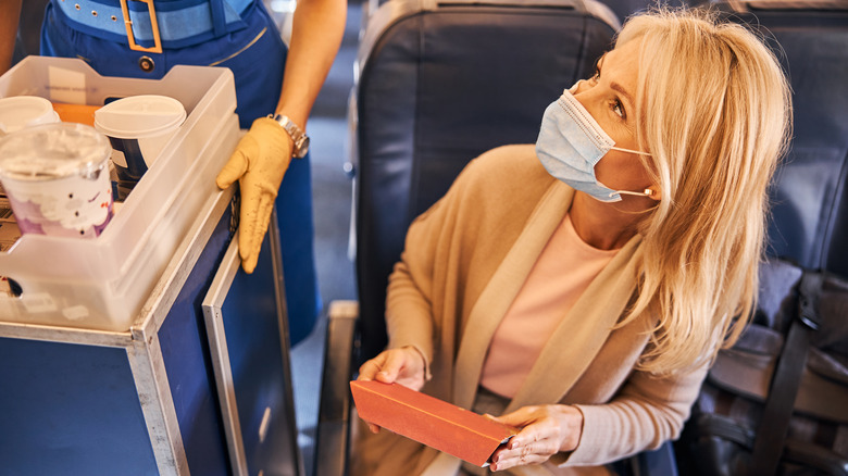 Woman holding box on airplane