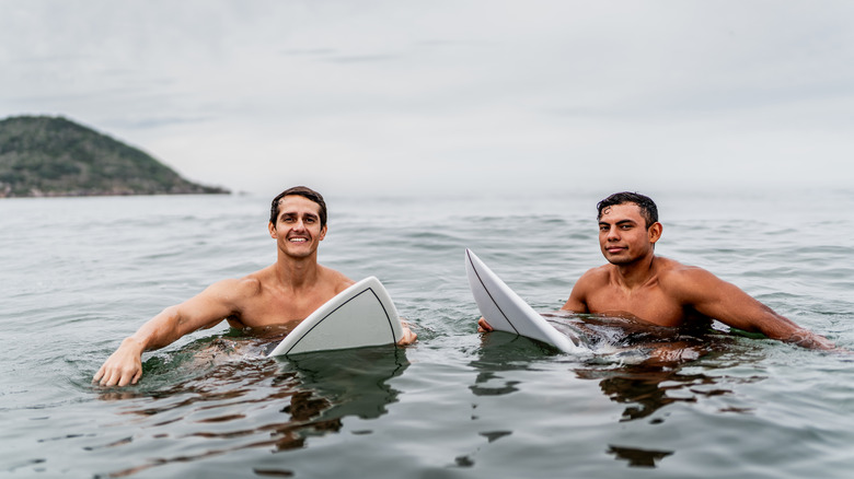 Men sitting on surfboards