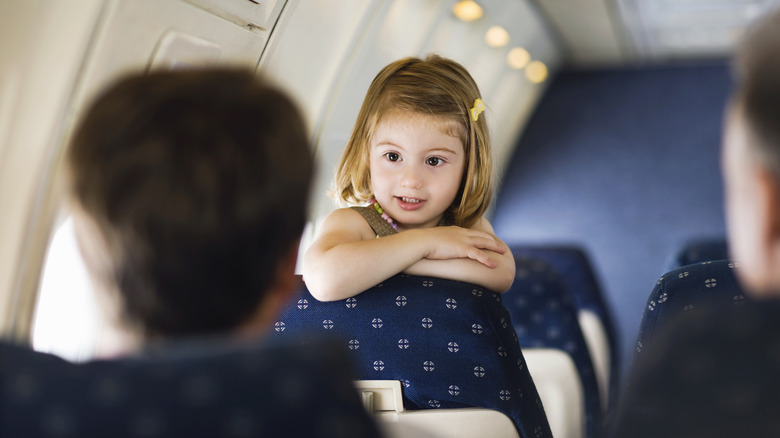 A child talking to her parent inside a plane