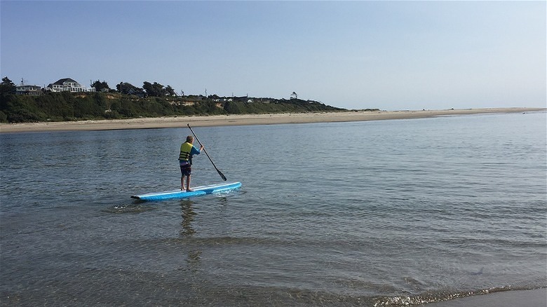 Man paddle boarding in Waldport, Oregon