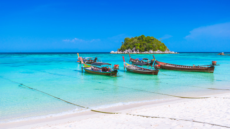 Long-tail boats in aquamarine sea in Thailand