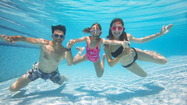 family underwater in a pool