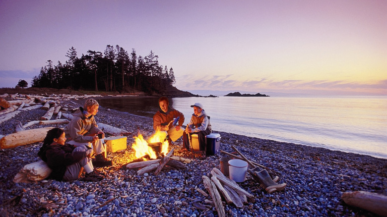 Young friends enjoy a beach fire on Whidbey Island, Washington